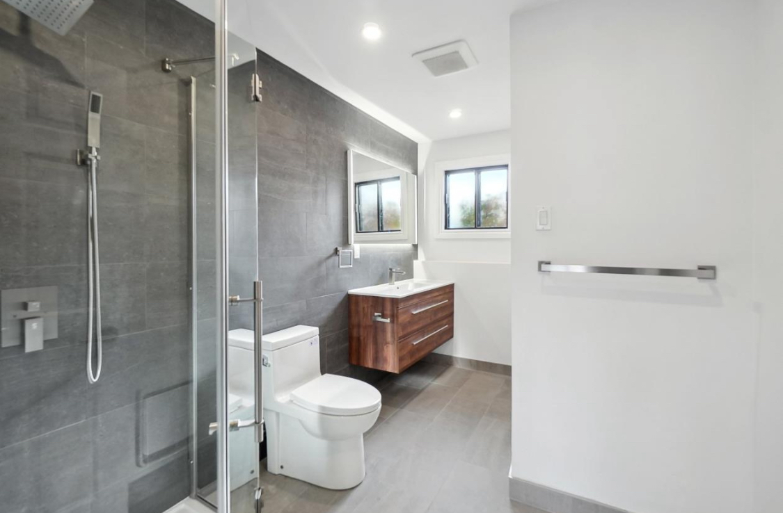 Modern basement bathroom with glass shower and vanity in West Island Montreal