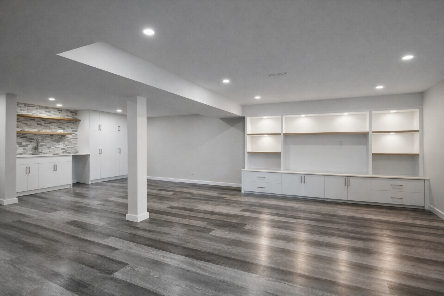 Modern basement renovation with built-in bar, custom cabinetry, and wall unit storage in Montreal