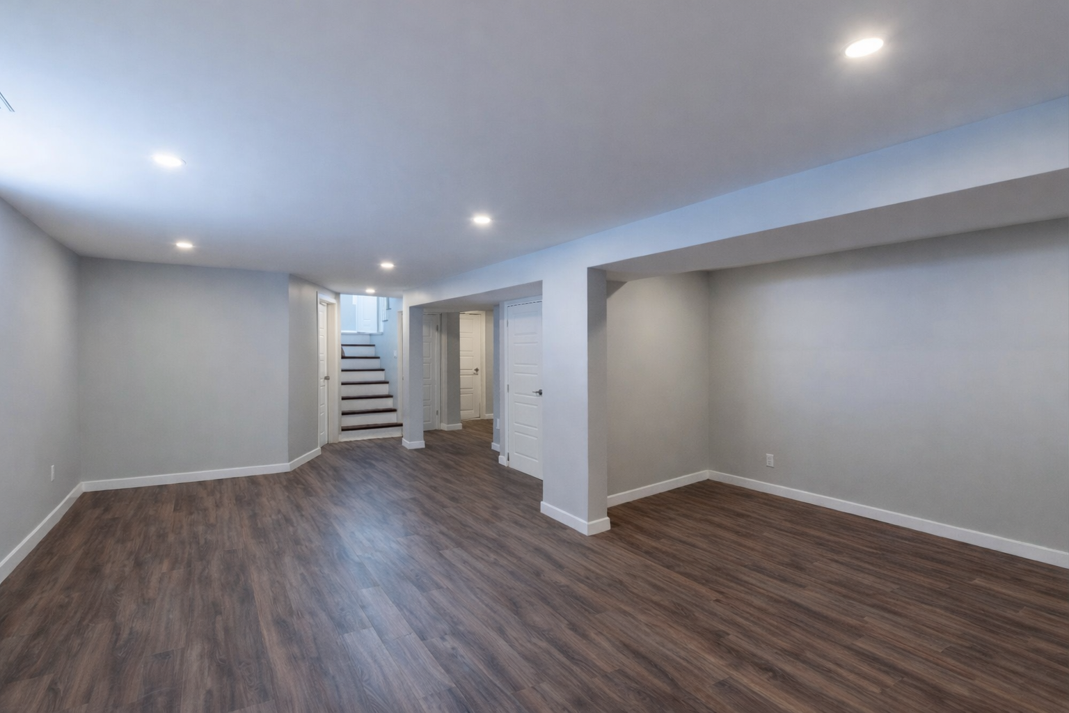 Finished basement with open layout and wood flooring in West Island Montreal