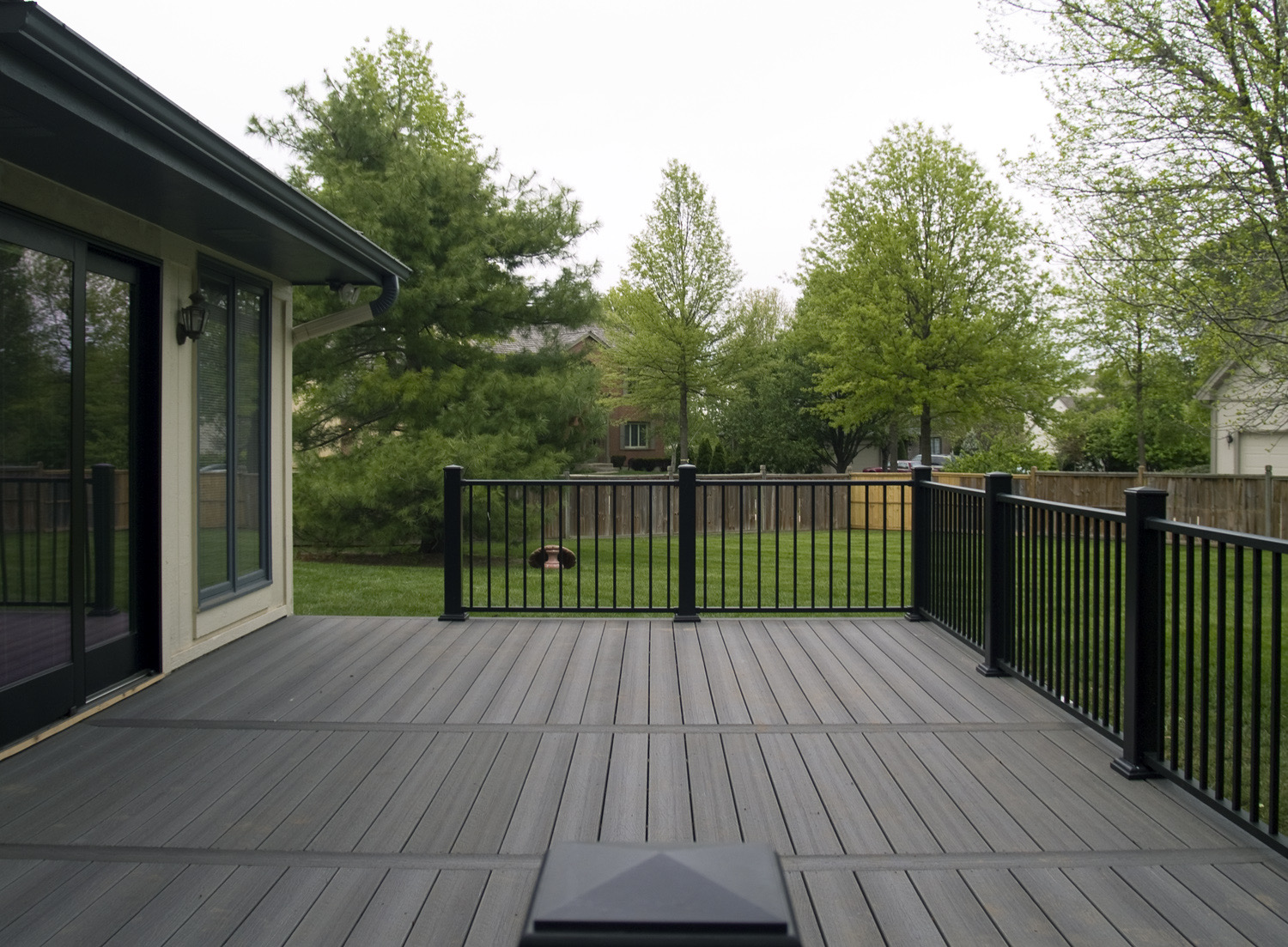 Grey composite deck with black aluminum railing in West Island Montreal backyard