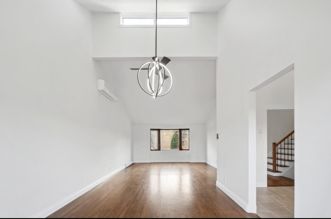 High ceiling living room renovation in West Island Montreal featuring vaulted ceiling, hardwood flooring and open interior layout with modern finishes, serving Dorval, Pointe-Claire, Pierrefonds, Kirkland, Beaconsfield, Dollard-Des-Ormeaux and Vaudreuil-Dorion