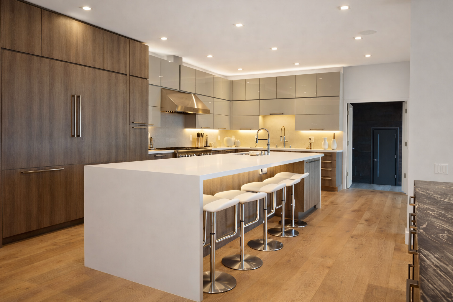 Luxury modern kitchen renovation in West Island Montreal with large island, wood cabinetry, integrated lighting and seating
