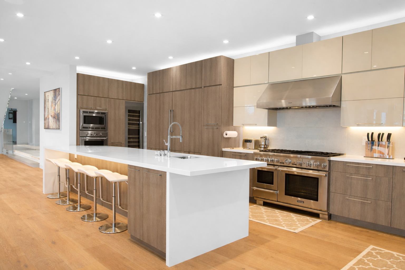 Modern kitchen renovation in West Island Montreal with large island seating, custom cabinets and quartz countertops