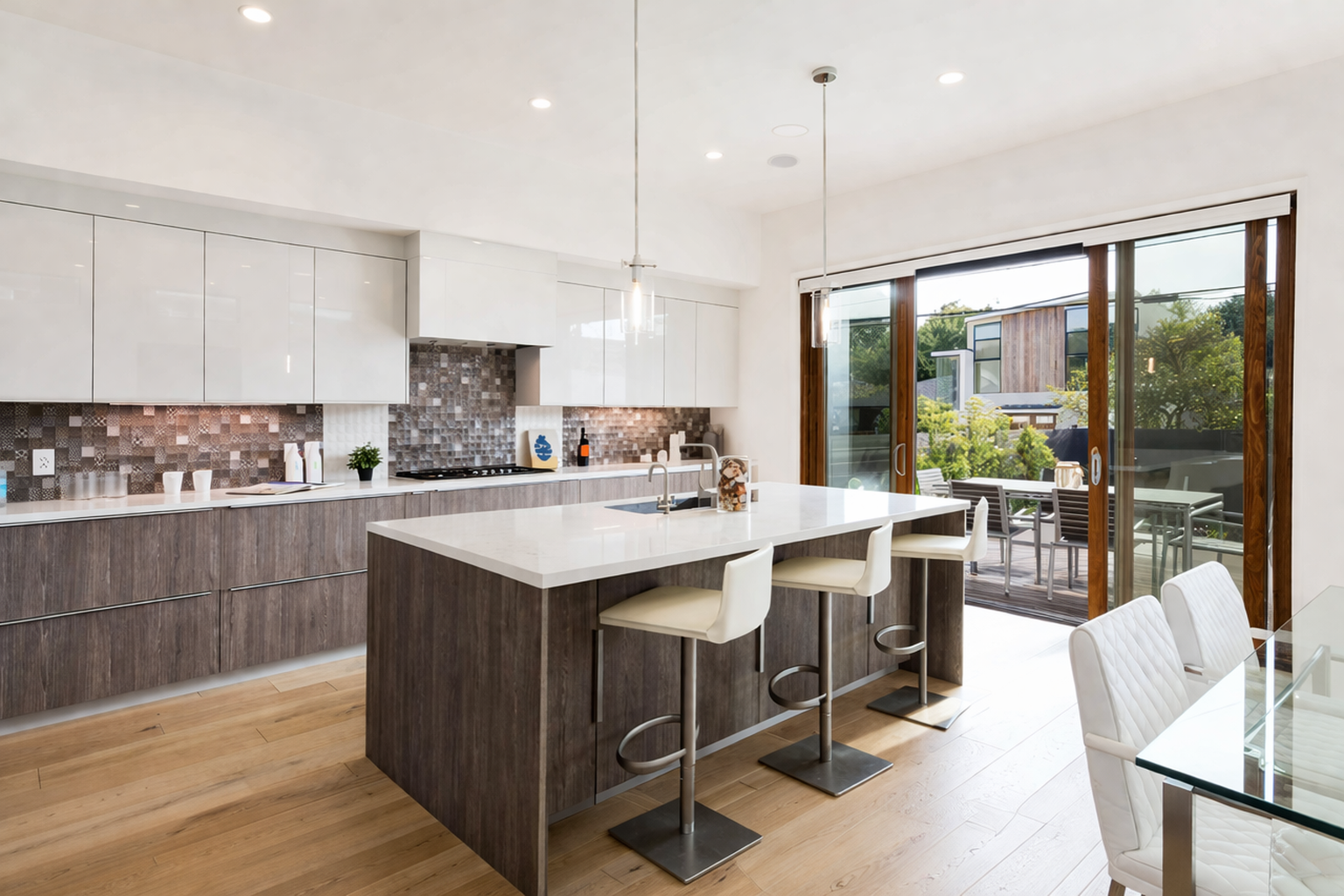 Modern kitchen renovation in West Island Montreal with two tone cabinets, large island seating and quartz countertops