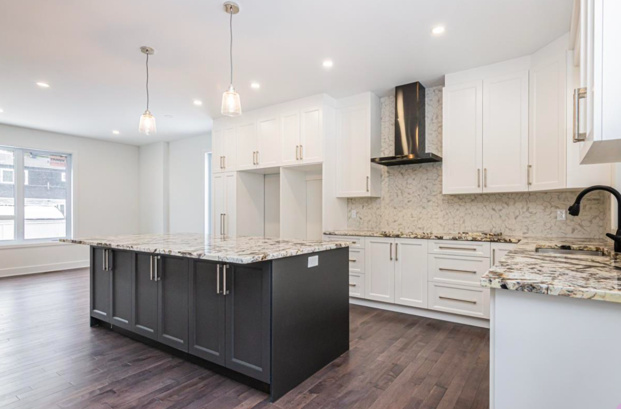 Modern kitchen renovation in West Island Montreal with white shaker cabinets, large island and quartz countertops