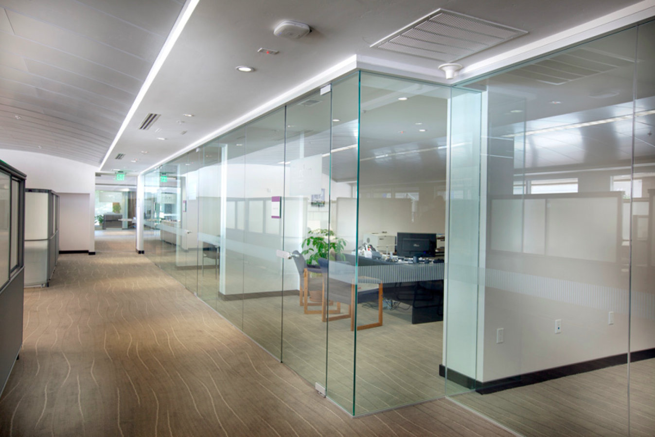 Commercial office renovation in West Island Montreal featuring glass partition walls, modern workspace layout, and professional interior finishes