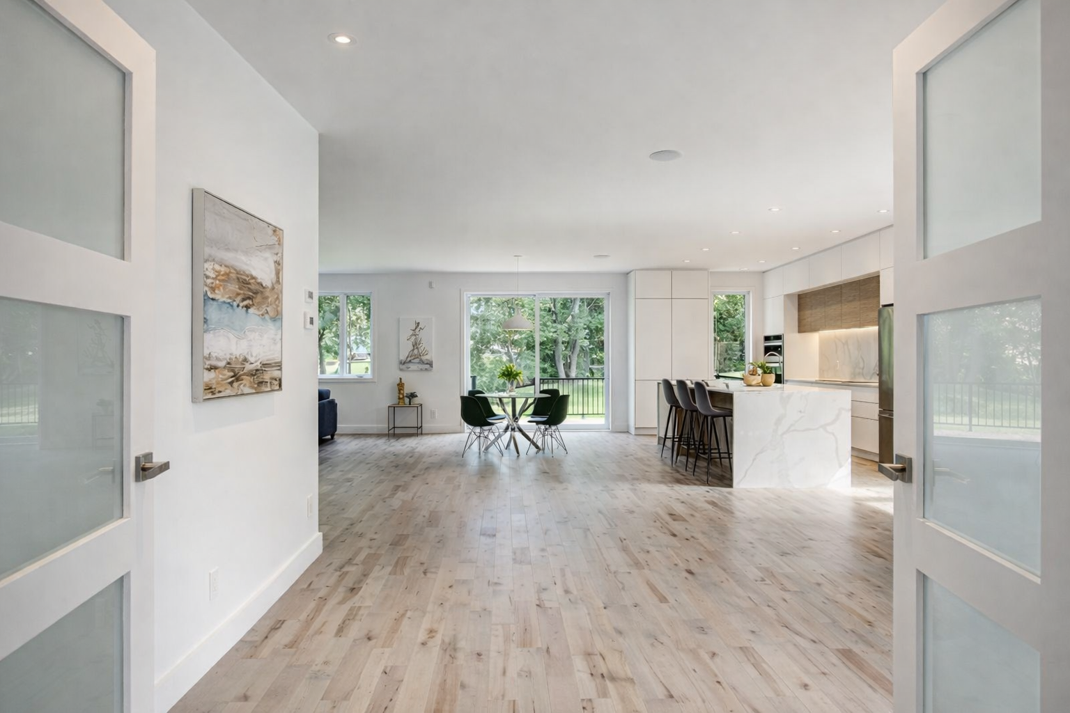 Open-concept home renovation in West Island Montreal featuring modern kitchen with Carrara quartz island, wood flooring and bright interior finishes, serving Dorval, Pointe-Claire, Pierrefonds, Kirkland, Beaconsfield, Dollard-Des-Ormeaux and Vaudreuil-Dorion