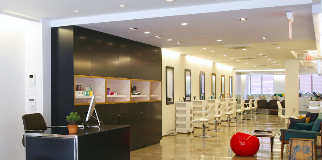 Hair salon renovation in West Island Montreal featuring modern styling stations, custom cabinetry, polished floors and professional commercial interior design