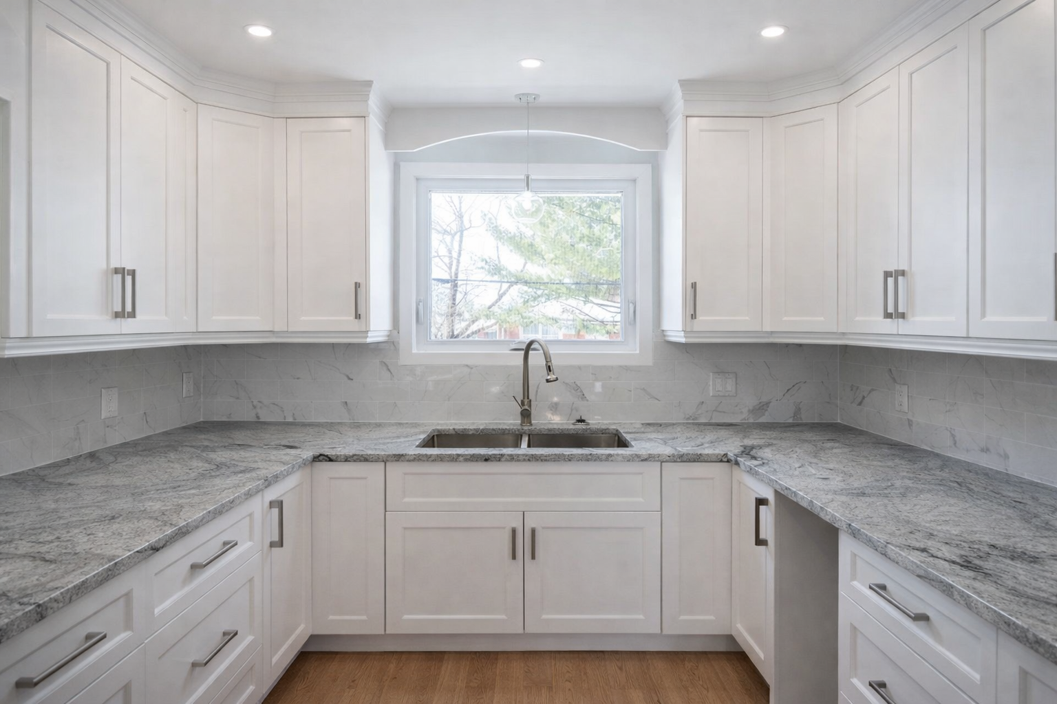 White kitchen renovation in West Island Montreal with Carrara quartz countertops, shaker cabinets and tile backsplash